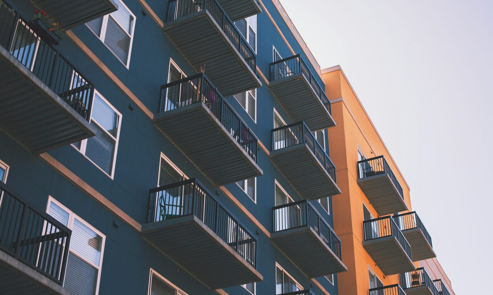 Blue and orange apartment building exterior photographed from below