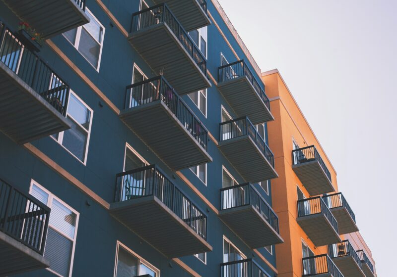 Blue and orange apartment building exterior photographed from below