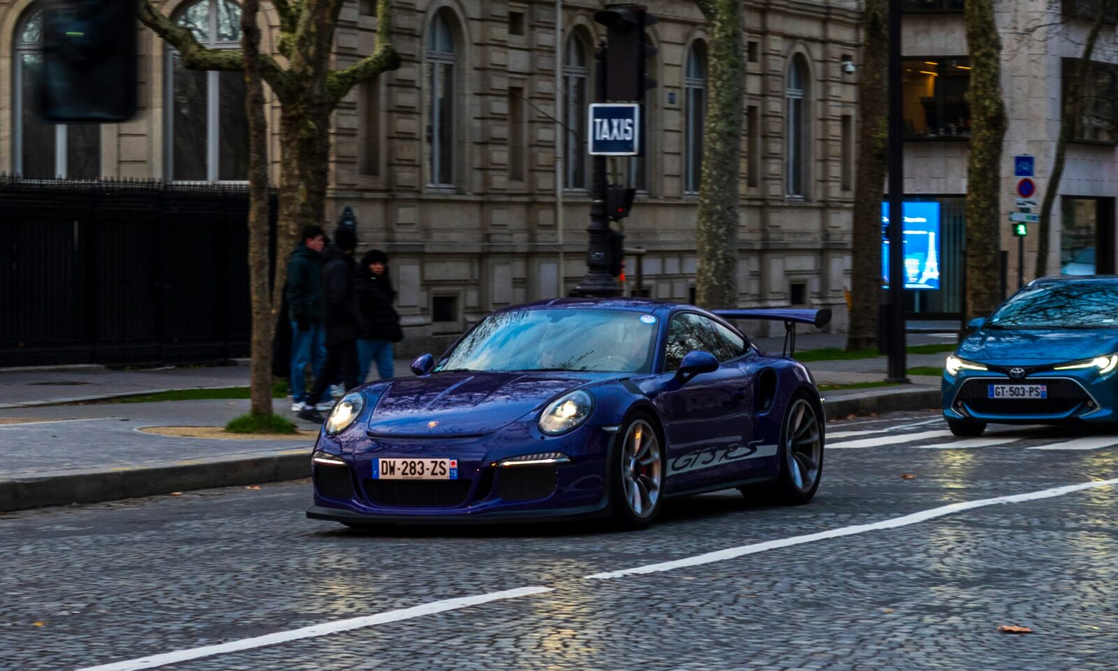 Illustrative photo of a modern car traveling along a European city street