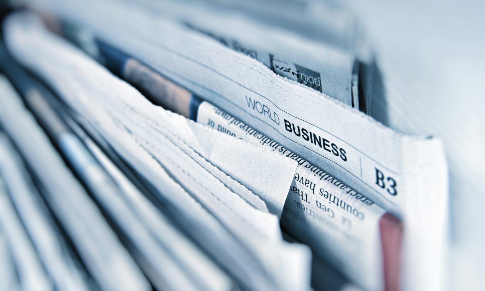 Business newspapers spread across a table