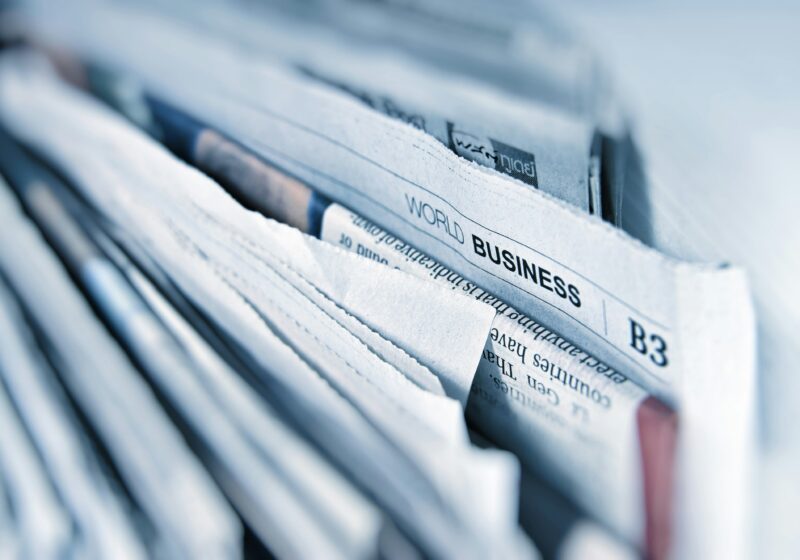 Business newspapers spread across a table