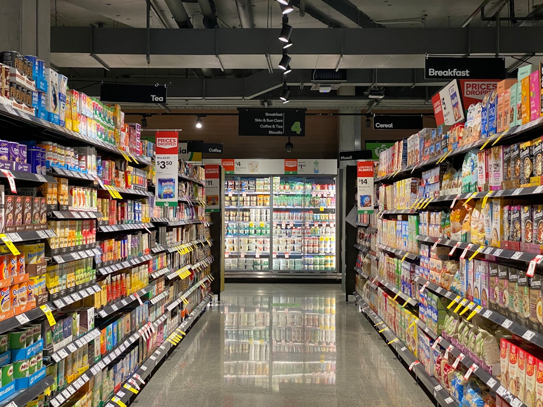 A brightly lit supermarket aisle lined with packaged food and beverage products.