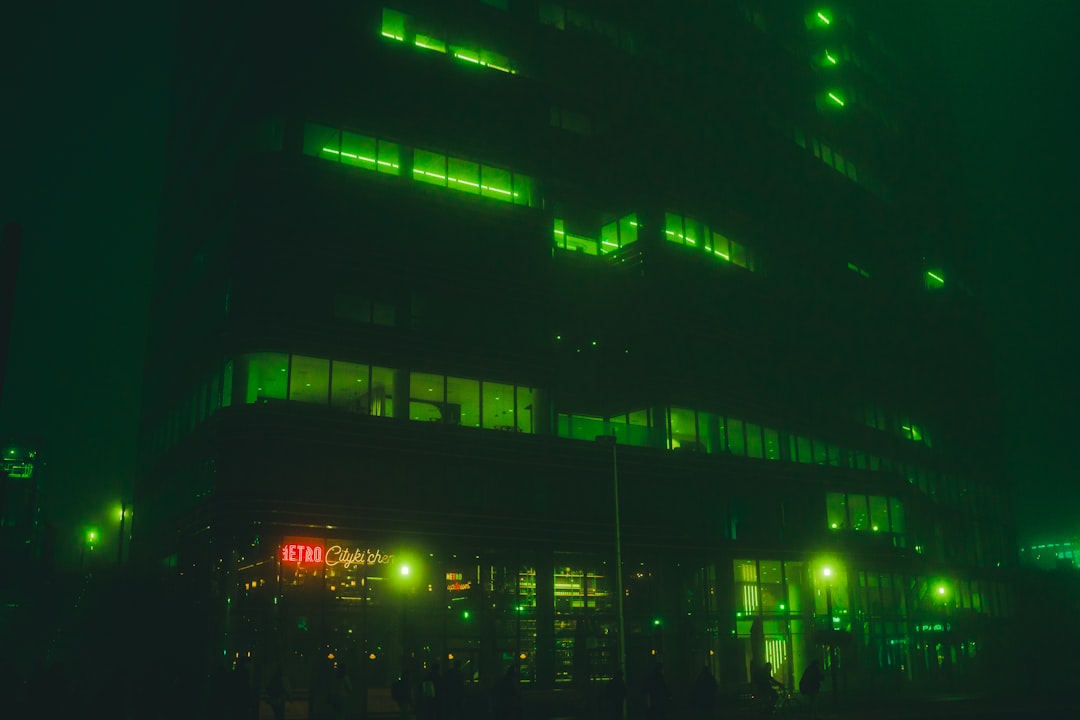 Building illuminated in green at night, illustrating the grounded mystery atmosphere of HBO's Lanterns.