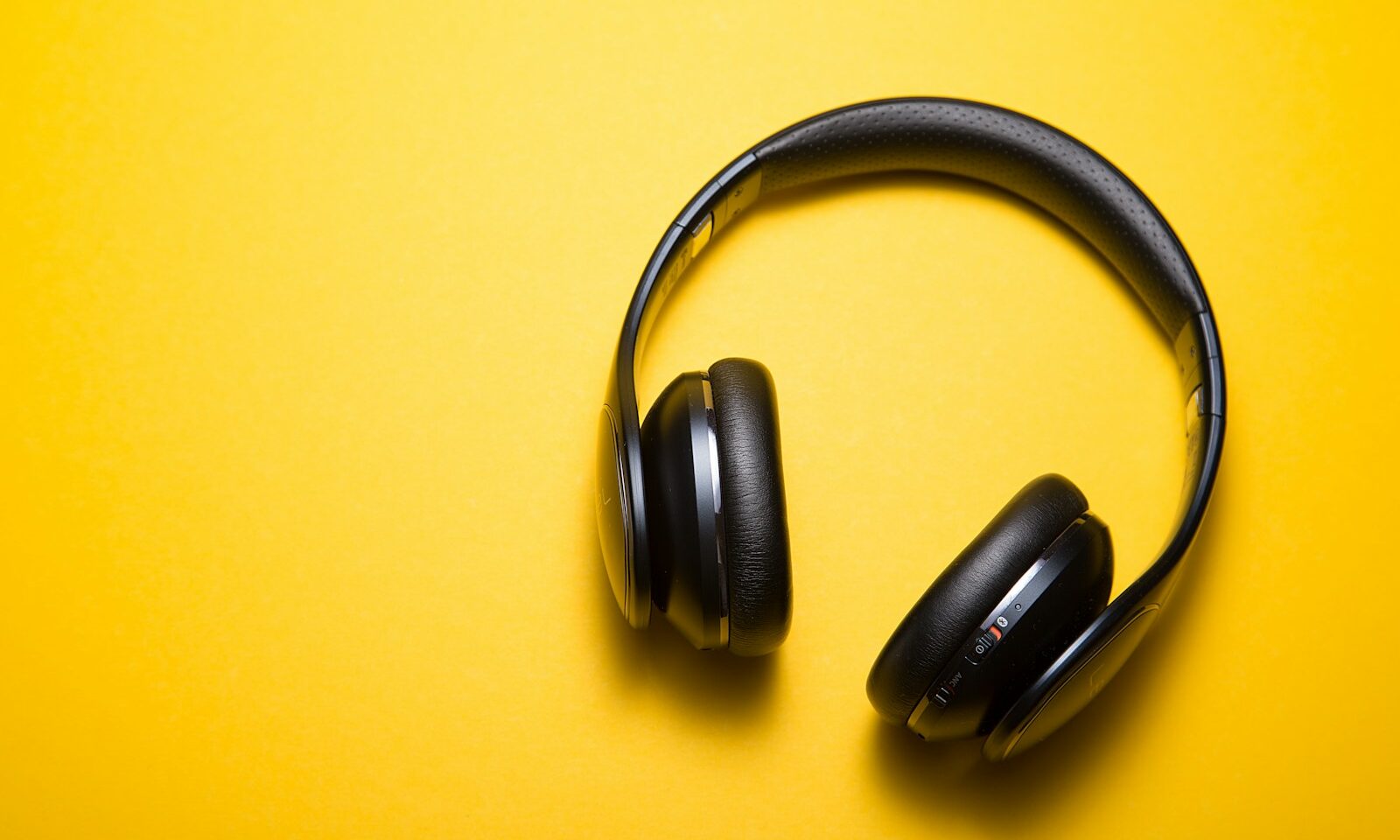 Wireless headphones on a surface, illustrating music playlist listening