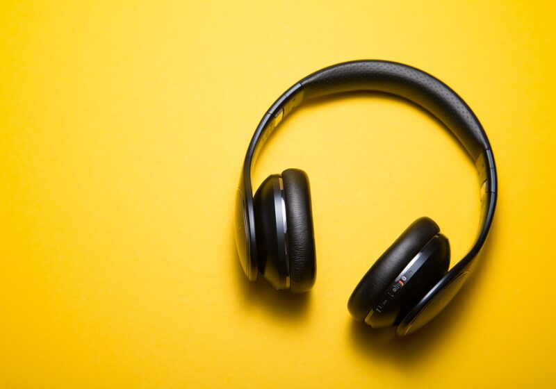 Wireless headphones on a surface, illustrating music playlist listening