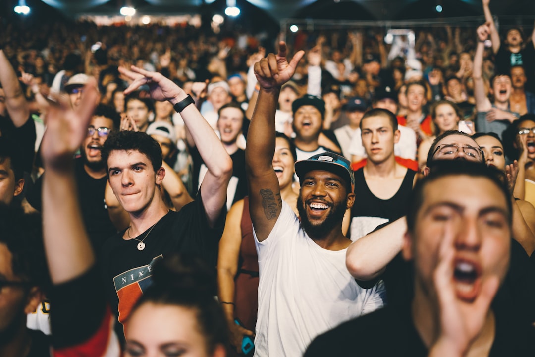 Large music festival crowd facing a brightly lit stage, illustrating Outside Lands as both a physical and livestreamed event.