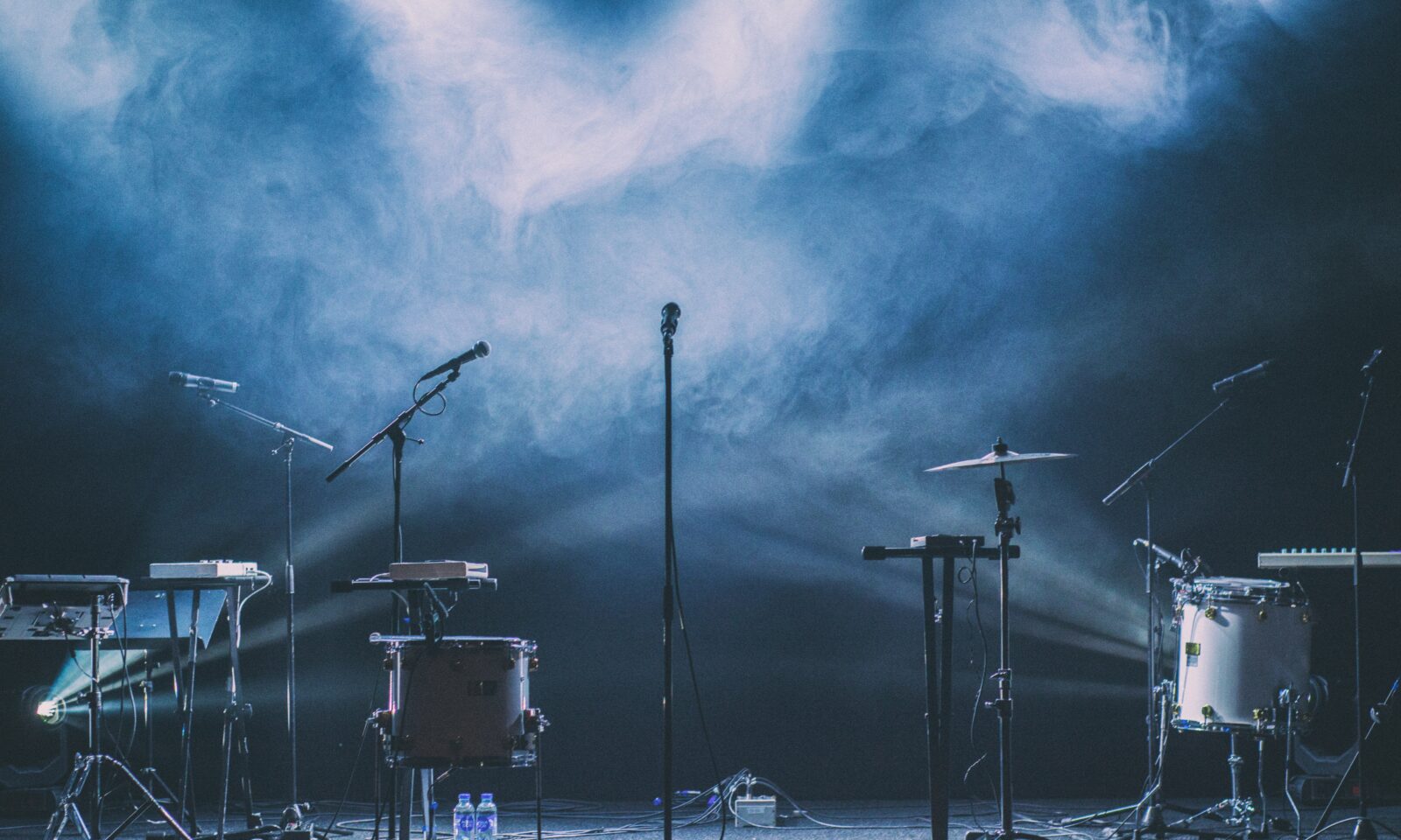 Illustrative photo of a microphone and stage lights at a live music performance