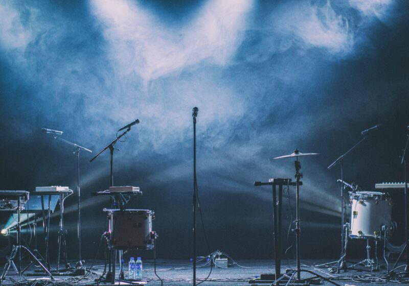 Illustrative photo of a microphone and stage lights at a live music performance