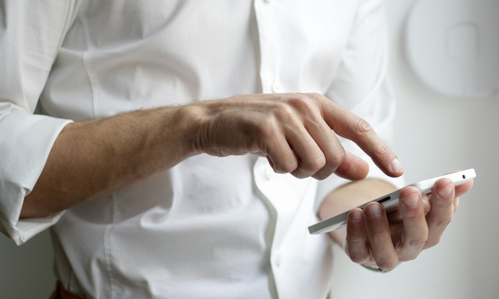 Person using a smartphone beside a laptop, illustrating digital news discovery