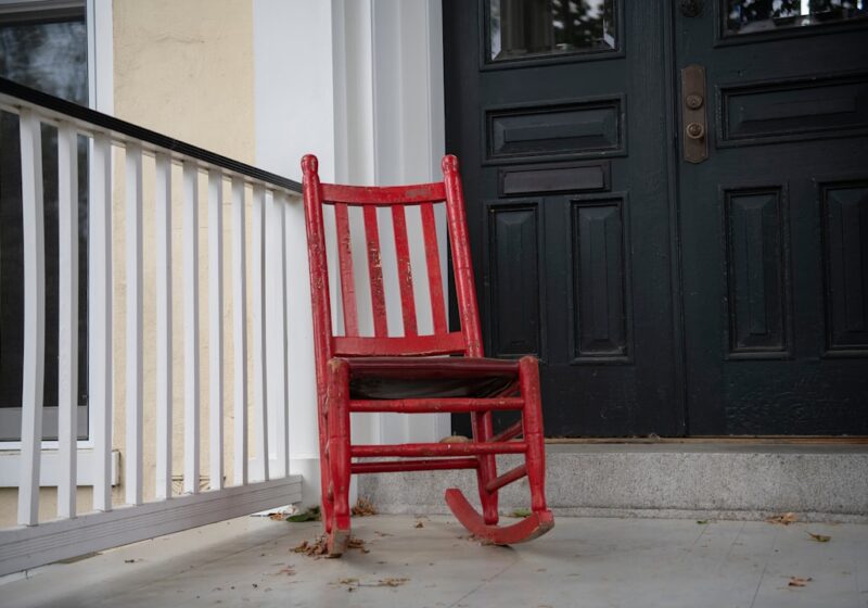 A wooden rocking chair on a front porch