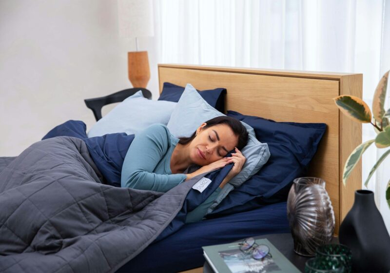 Person using a smartphone in bed, illustrating sleep tracking