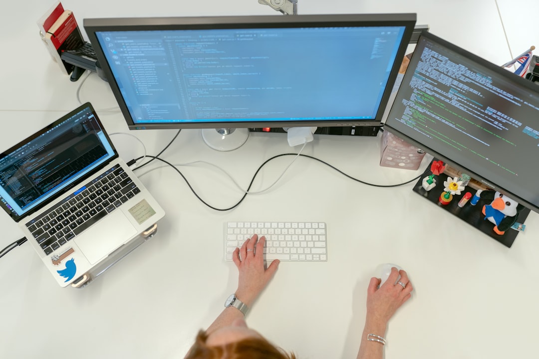 Software engineer working at multiple computer screens in an office