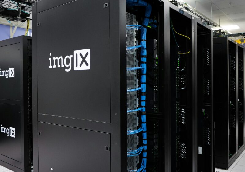 Rows of black server racks with blue network cables in a data center