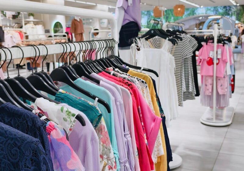 Colorful clothing displayed in a bright modern retail store.