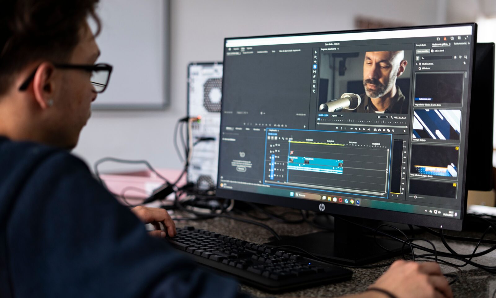A video editor works at a post-production workstation.