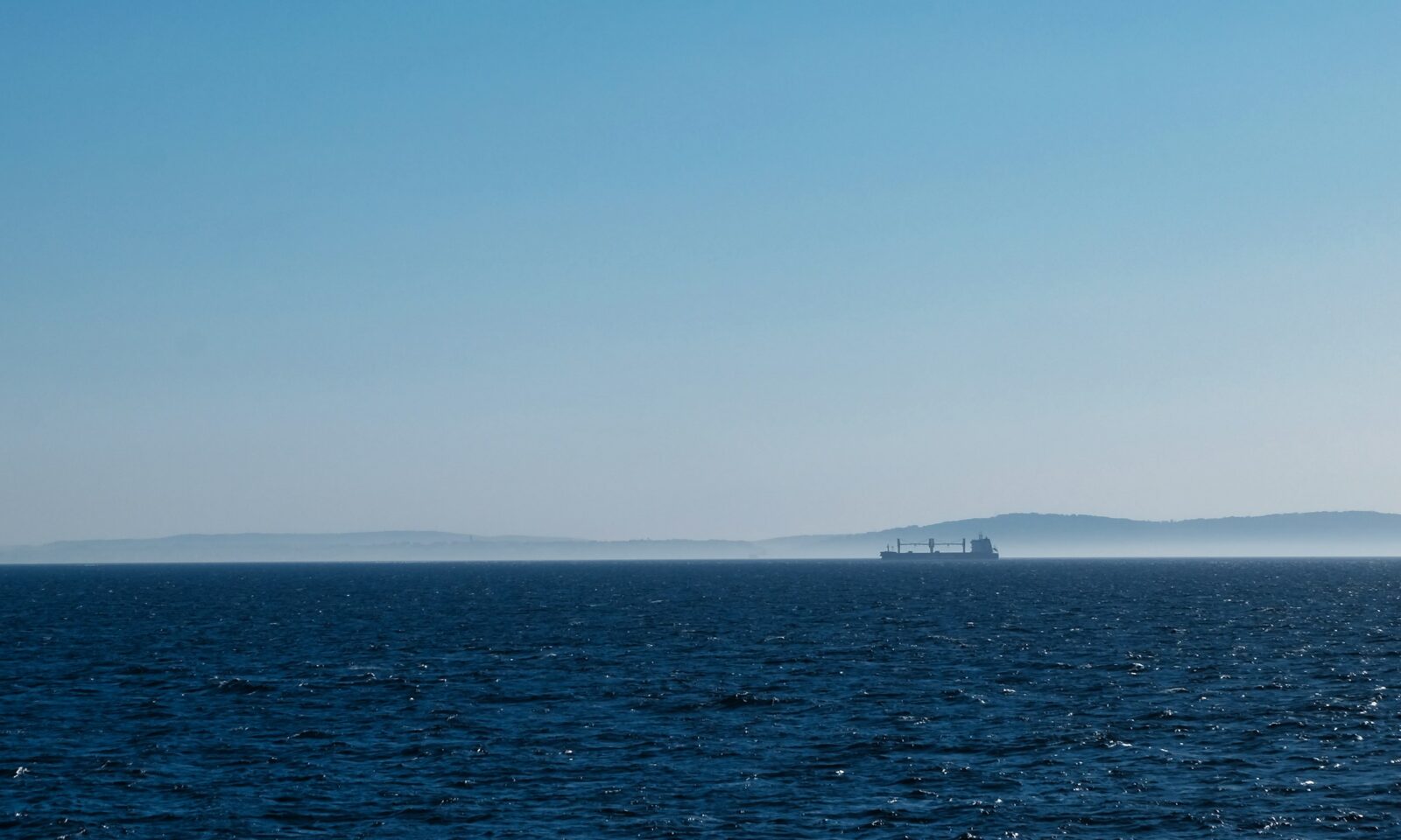 Cargo ship sailing on a clear blue ocean