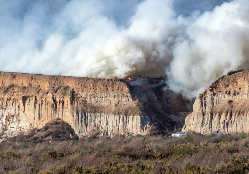 A large plume of wildfire smoke rising over a California mountainside