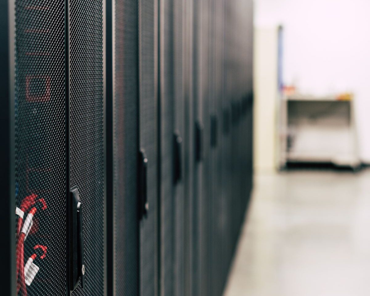 A row of black server cabinets with red cabling.