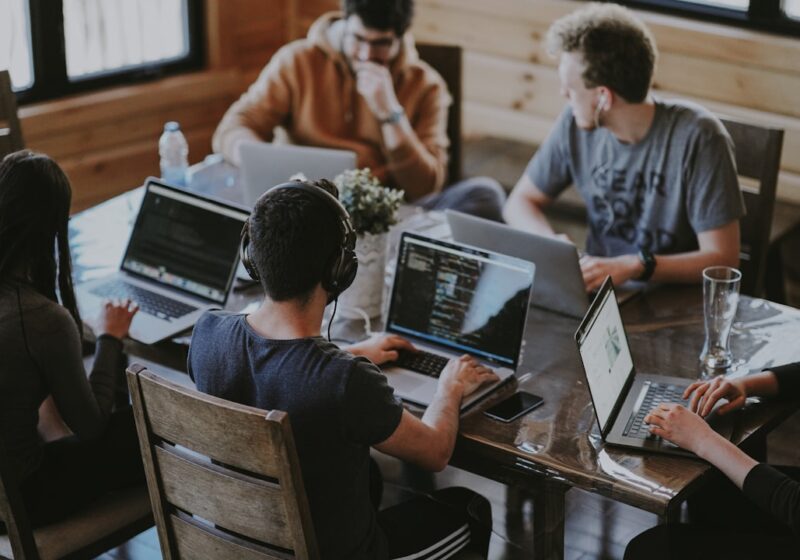 A team collaborating around computers, illustrating AI-enabled workforce transformation.