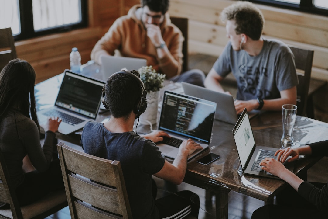 A team collaborating around computers, illustrating AI-enabled workforce transformation.