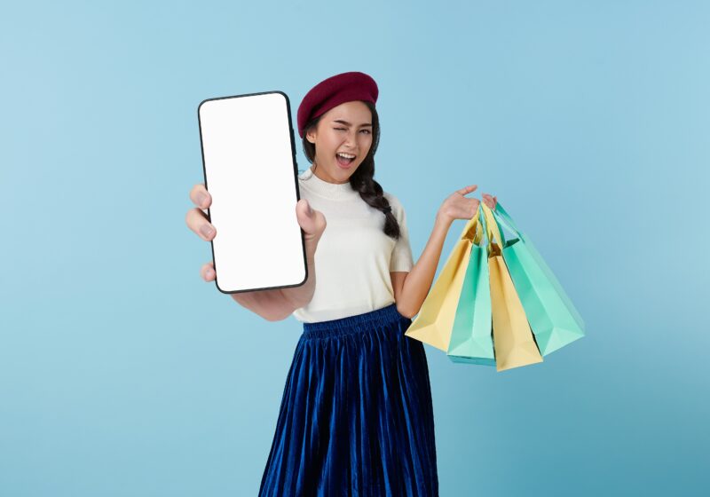 Shopper holding a tablet and shopping bags