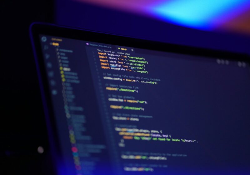 Developer working with code on multiple computer screens, illustrating game creation
