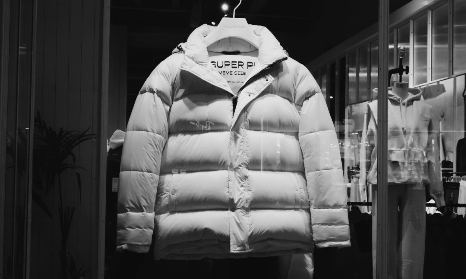 White puffer jacket displayed in a fashion storefront, illustrating Carter’s retail brand strategy