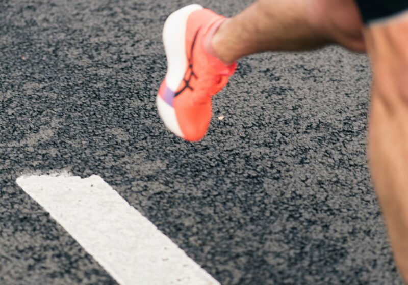 Runner's shoe crossing a white line on a track; illustrative image, not an On product.