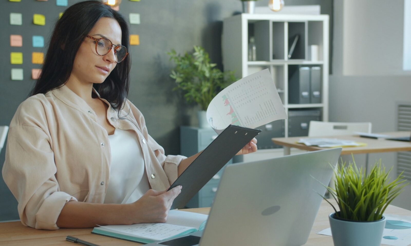 Professional reviewing printed documents beside a laptop, illustrating service-request processing