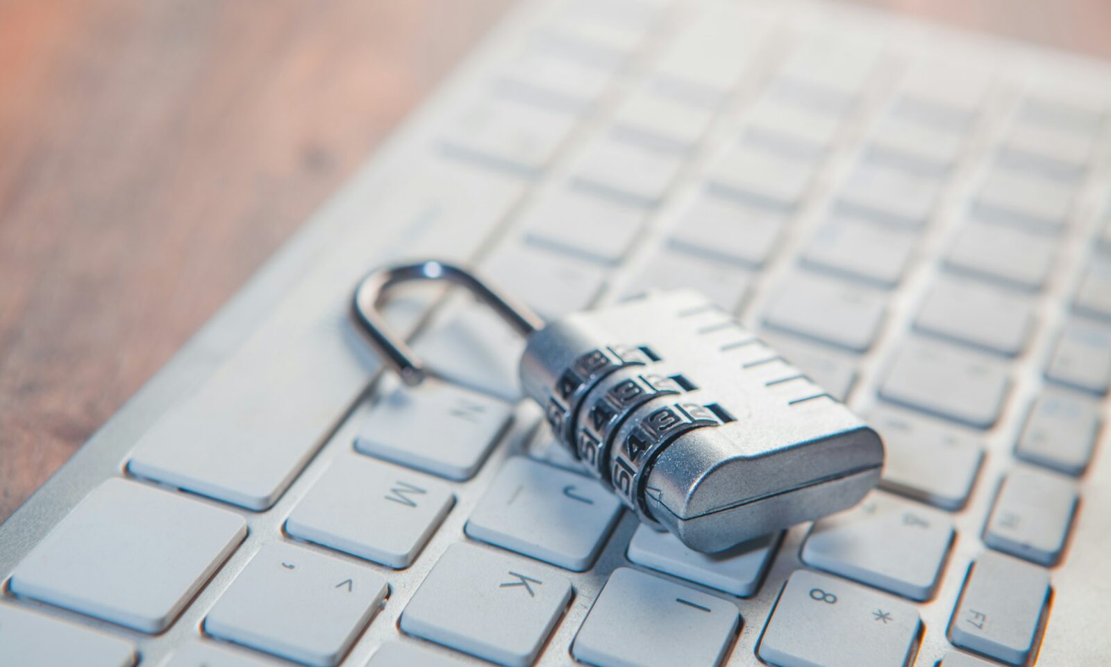 Combination lock resting on a computer keyboard.