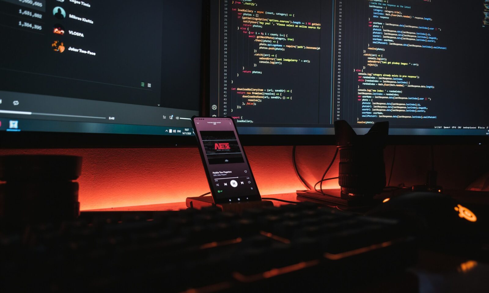 Computer monitors displaying software code in a developer workspace