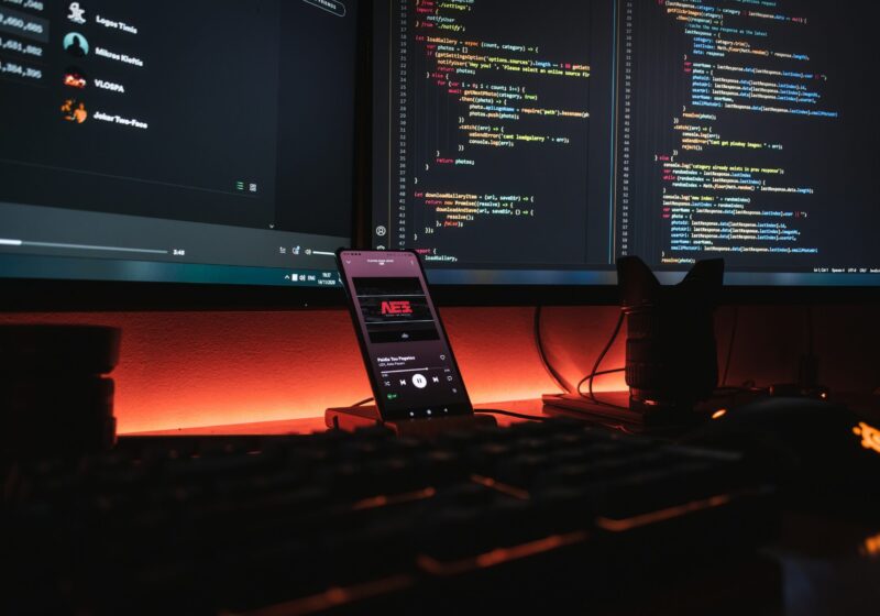 Computer monitors displaying software code in a developer workspace
