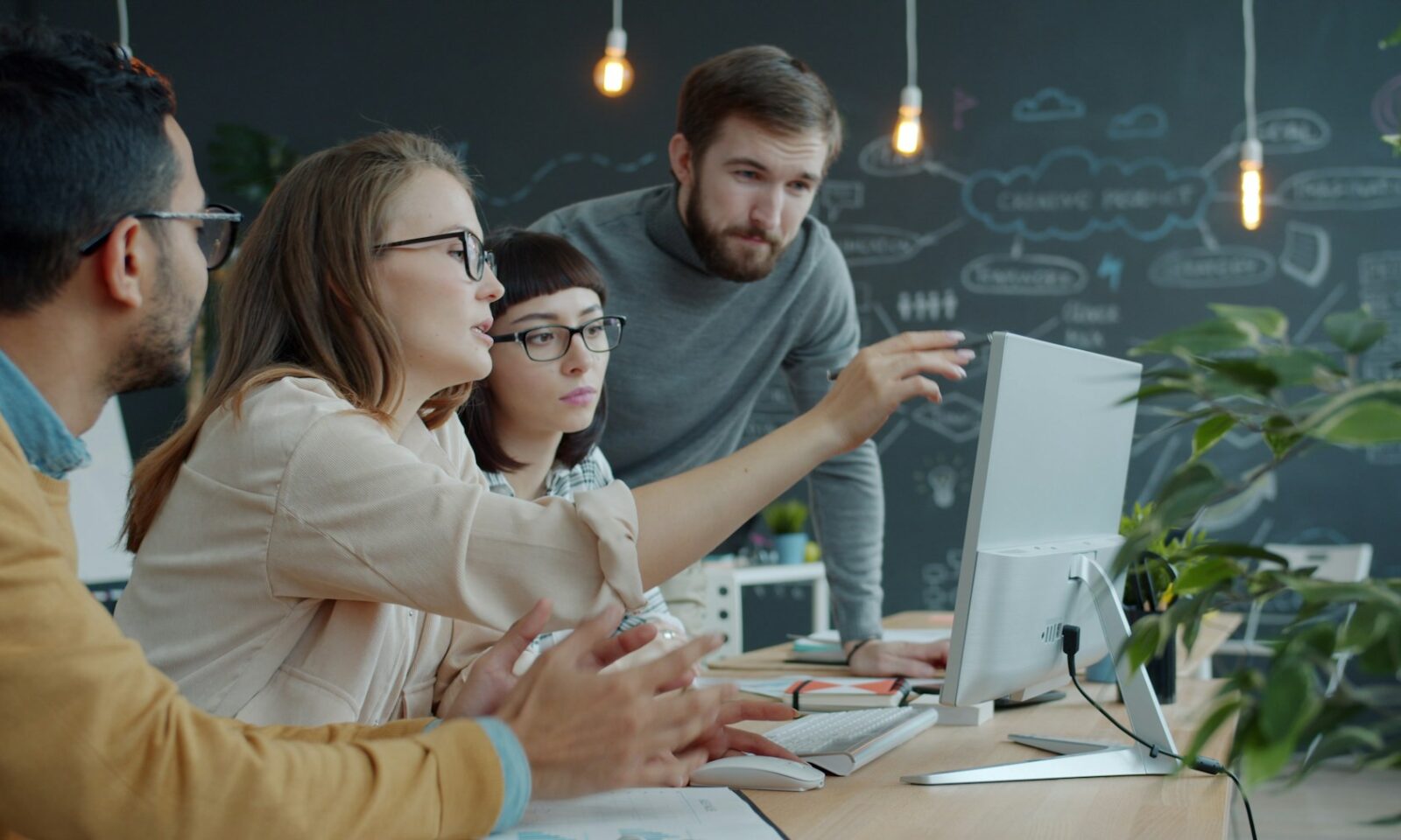 Team collaborating around a computer in an office