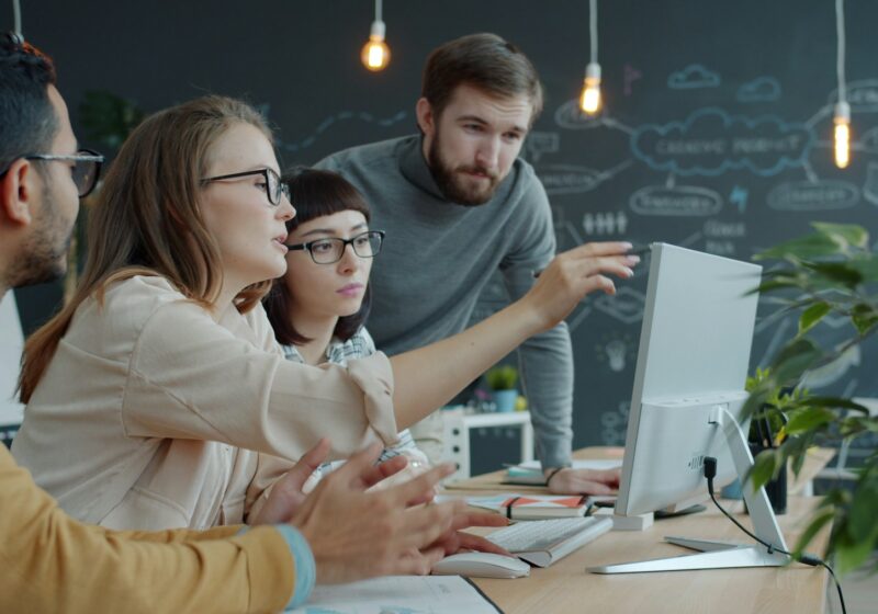 Team collaborating around a computer in an office