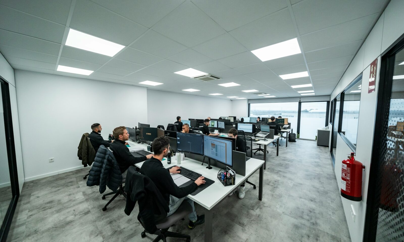 Technical team working at computer stations, illustrating monitored AI research operations