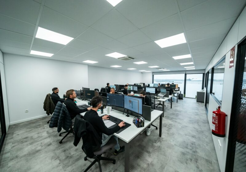 Technical team working at computer stations, illustrating monitored AI research operations