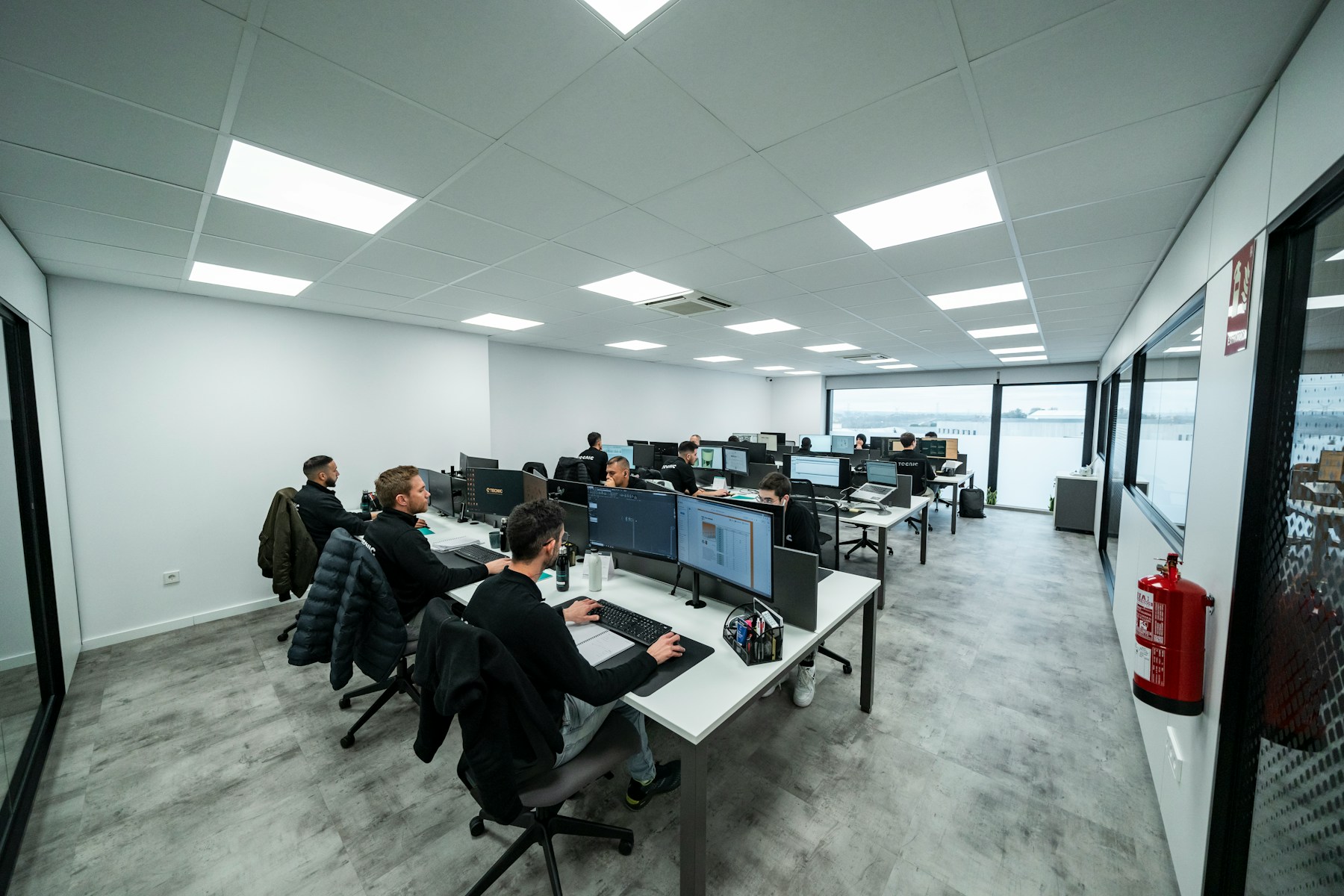 Technical team working at computer stations, illustrating monitored AI research operations