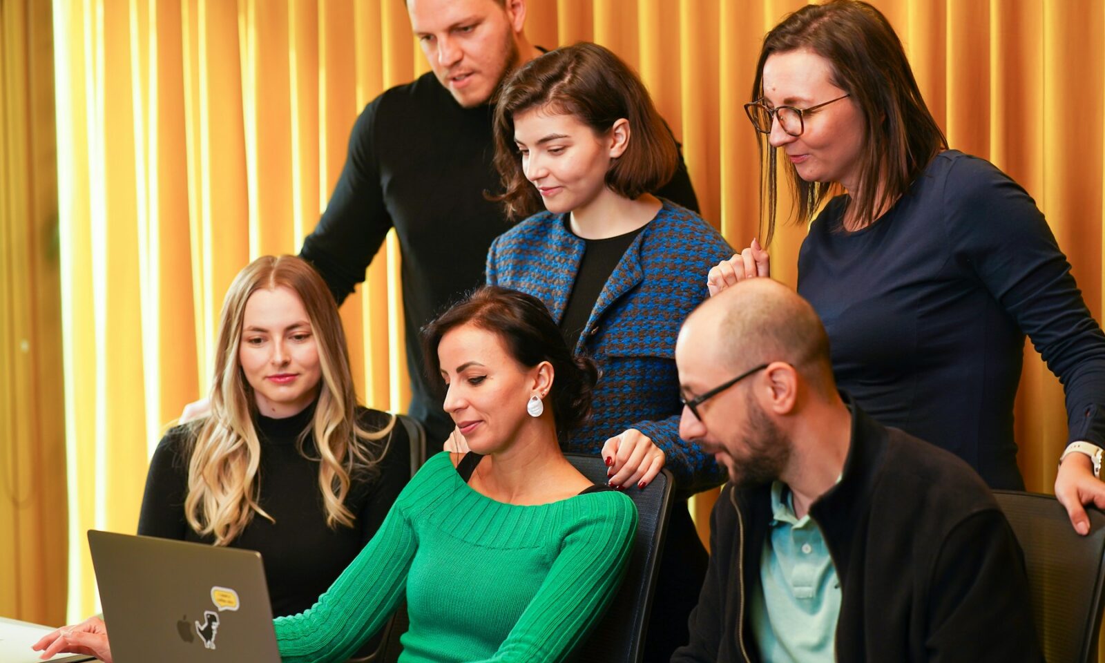 Colleagues reviewing a laptop, illustrating public debate about artificial intelligence