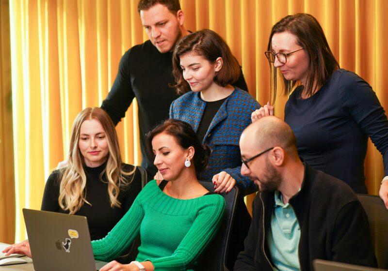 Colleagues reviewing a laptop, illustrating public debate about artificial intelligence