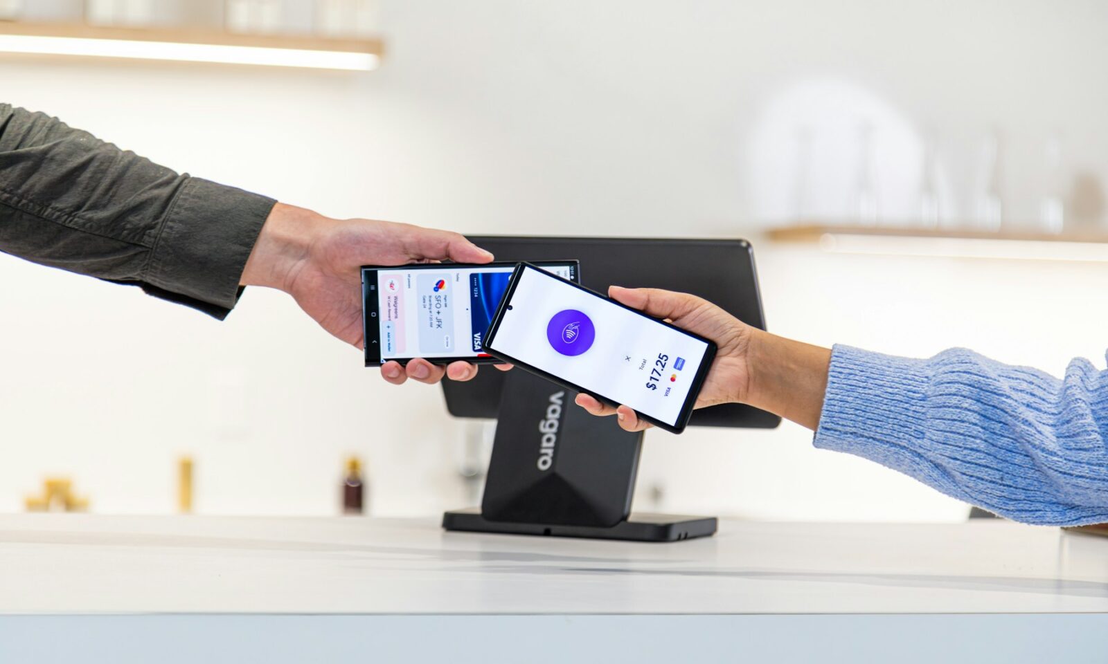 Customer making a contactless payment with a smartphone at a payment terminal
