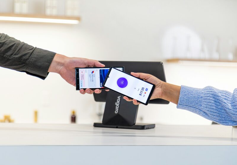 Customer making a contactless payment with a smartphone at a payment terminal