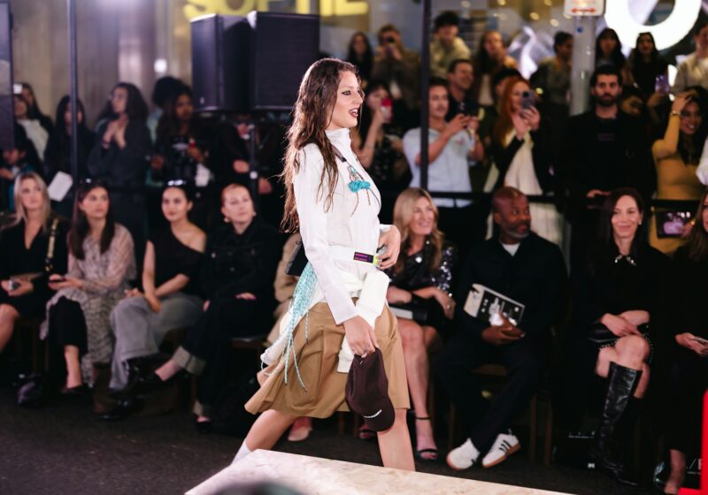 Model walking a fashion runway as an audience watches