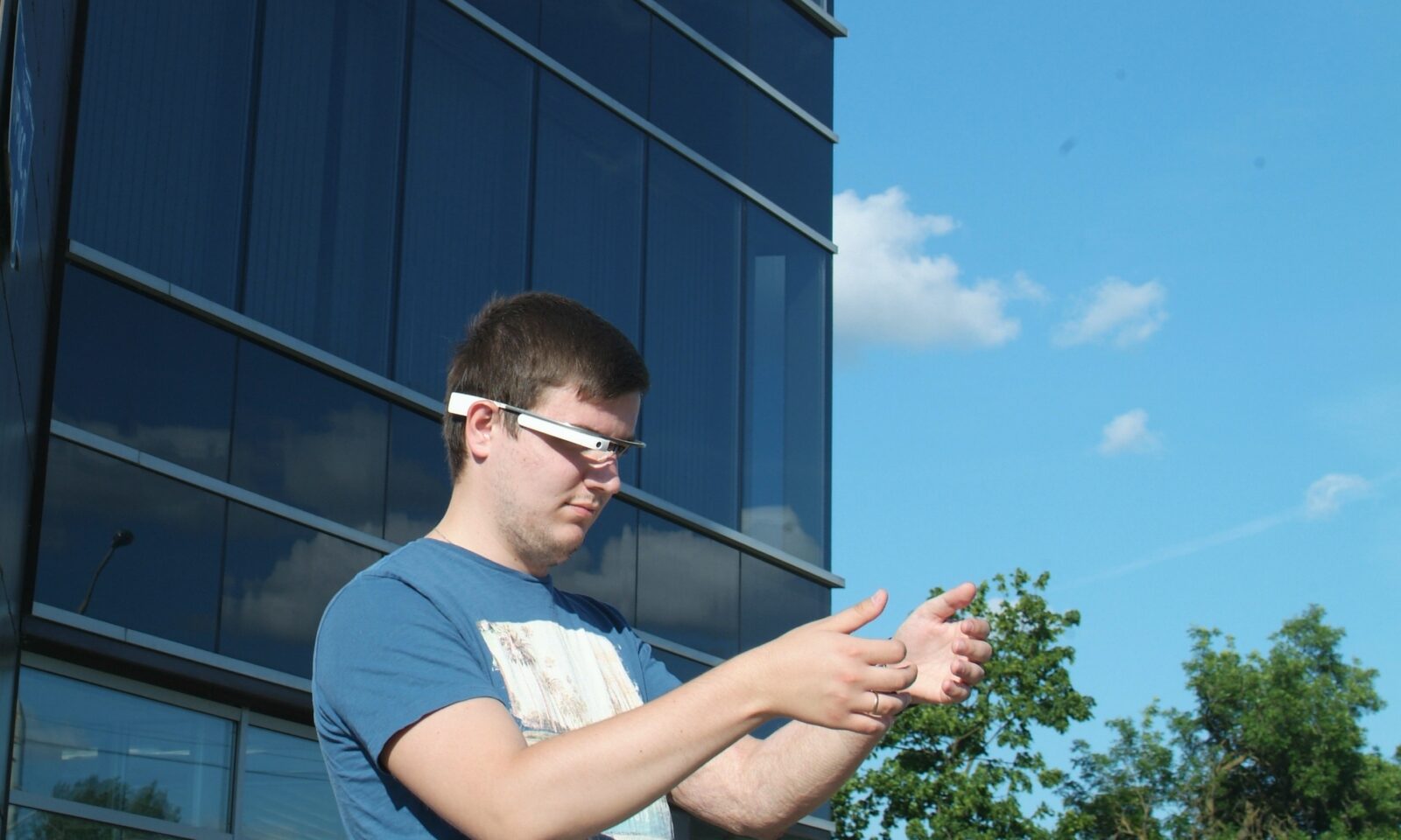 Person interacting with augmented-reality glasses and virtual objects.