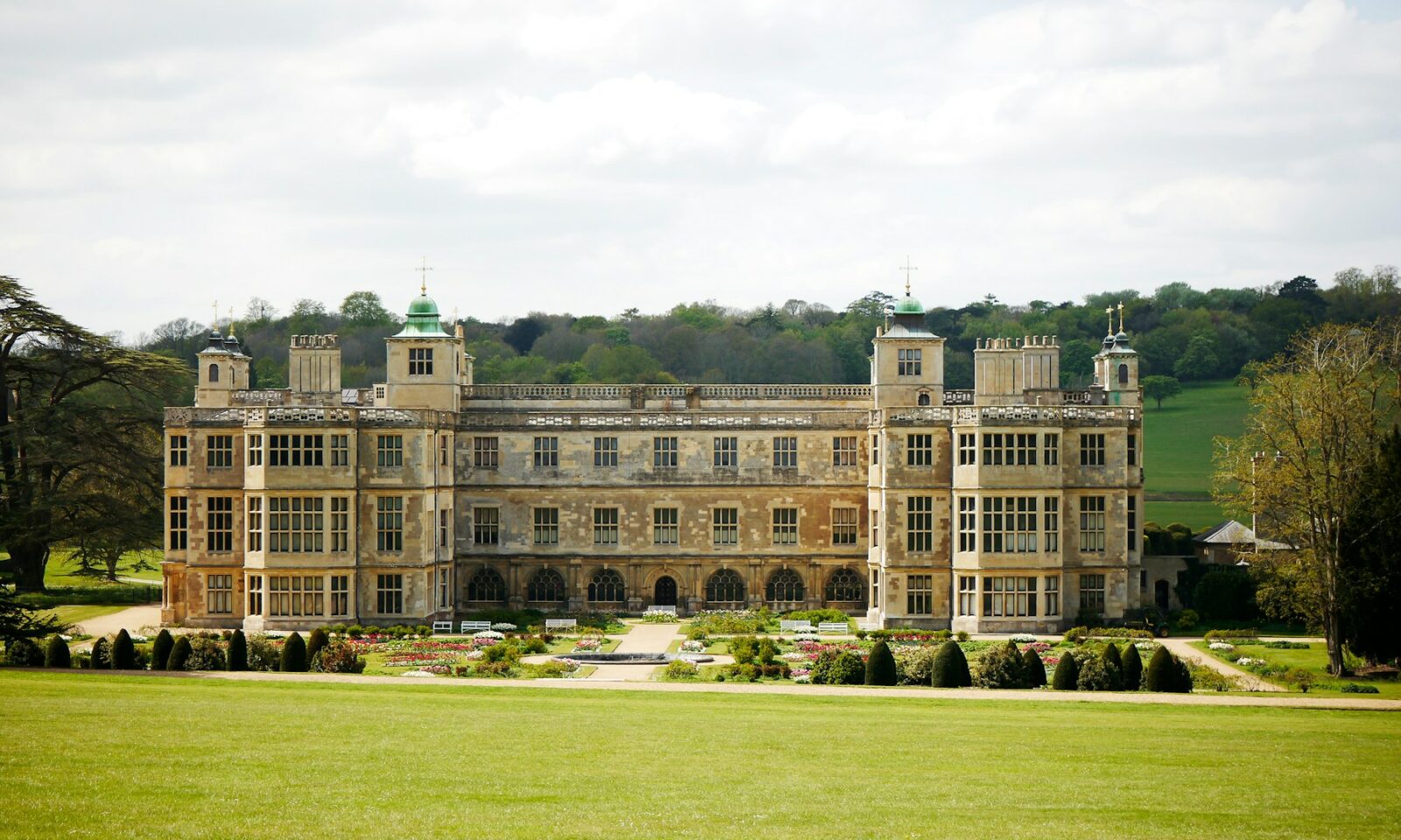 Historic English manor behind a green lawn, illustrating heritage property branding