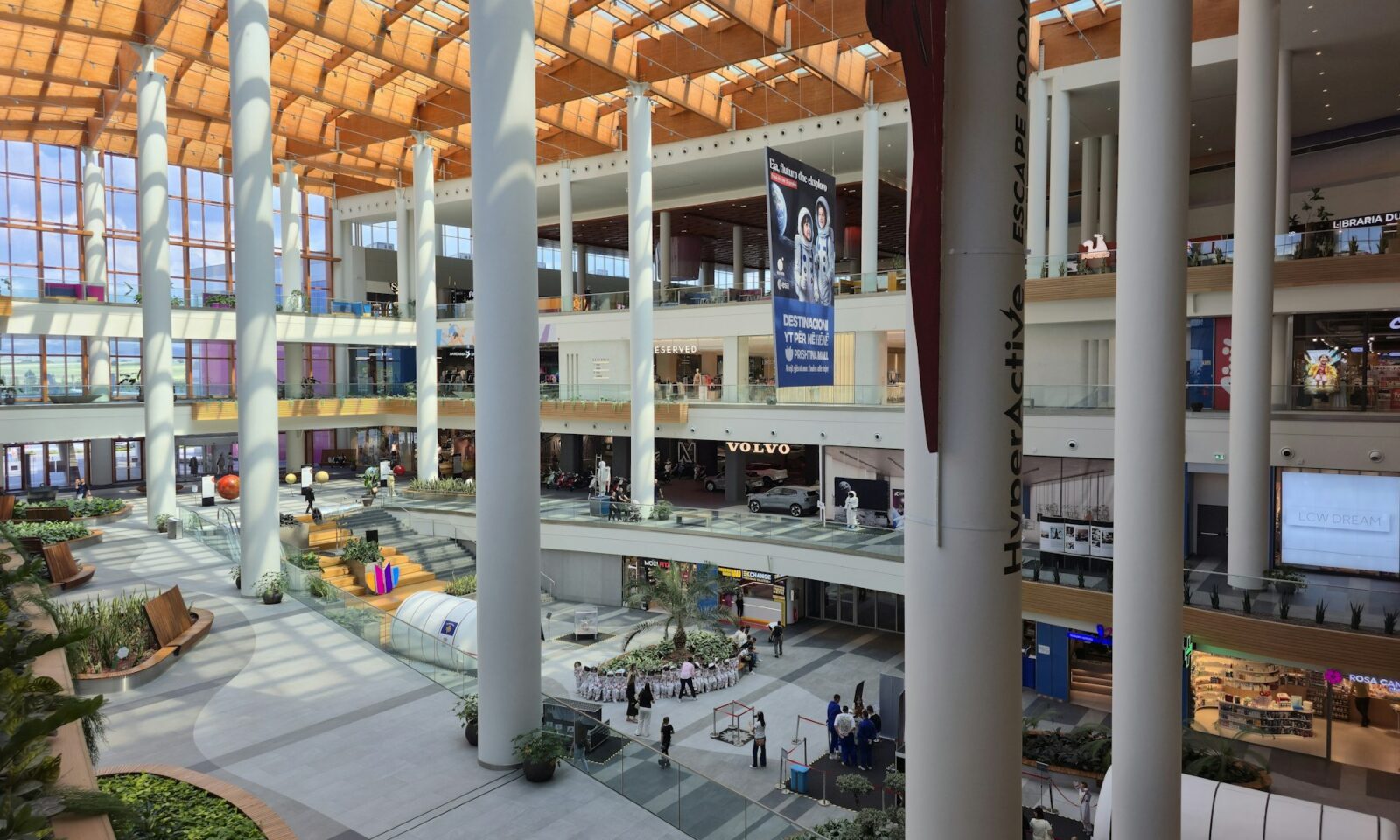Modern multilevel shopping mall interior with escalators and storefronts