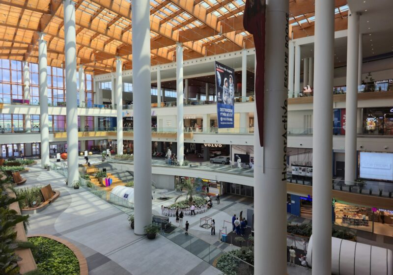 Modern multilevel shopping mall interior with escalators and storefronts