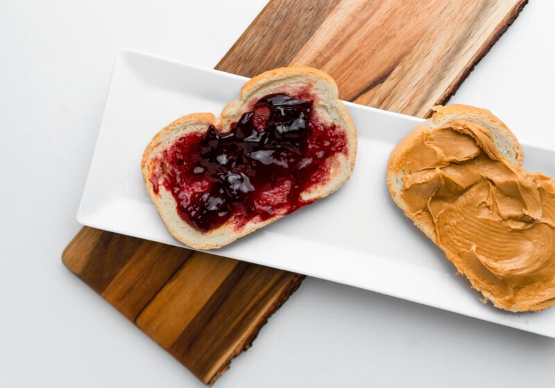 Open peanut butter and jelly sandwich on a white platter
