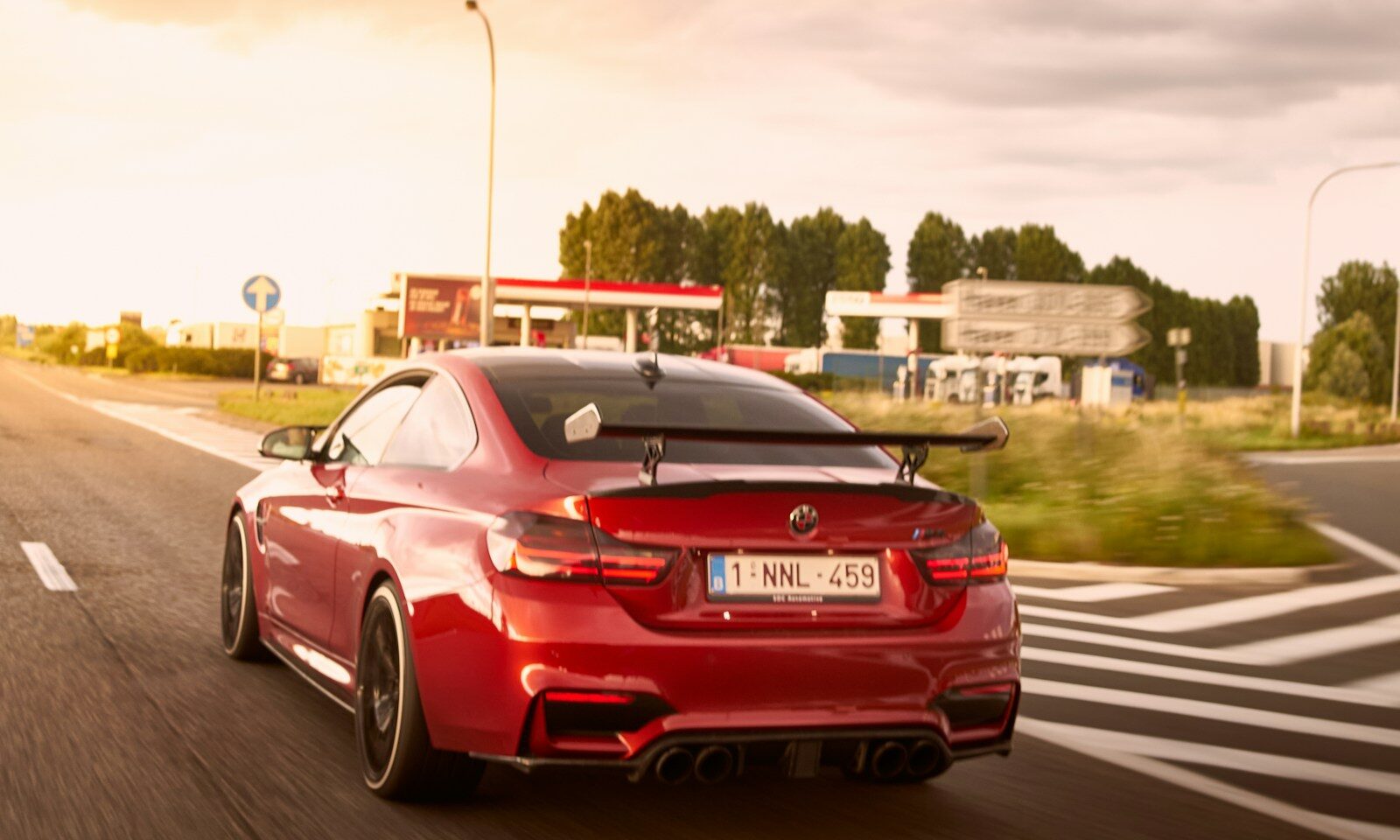 Red sports car traveling on a road, illustrative image