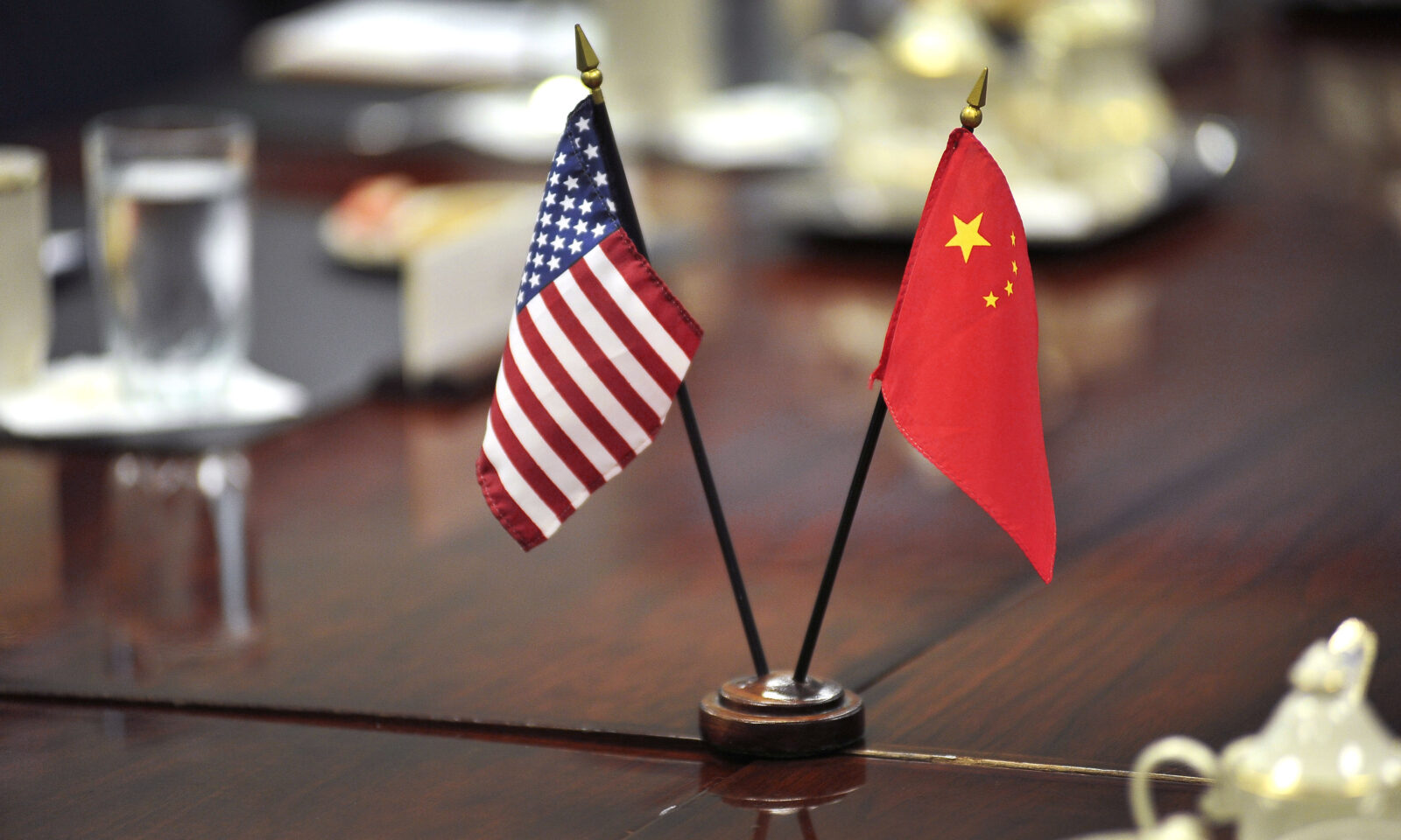 United States and Chinese flags standing together at a meeting table
