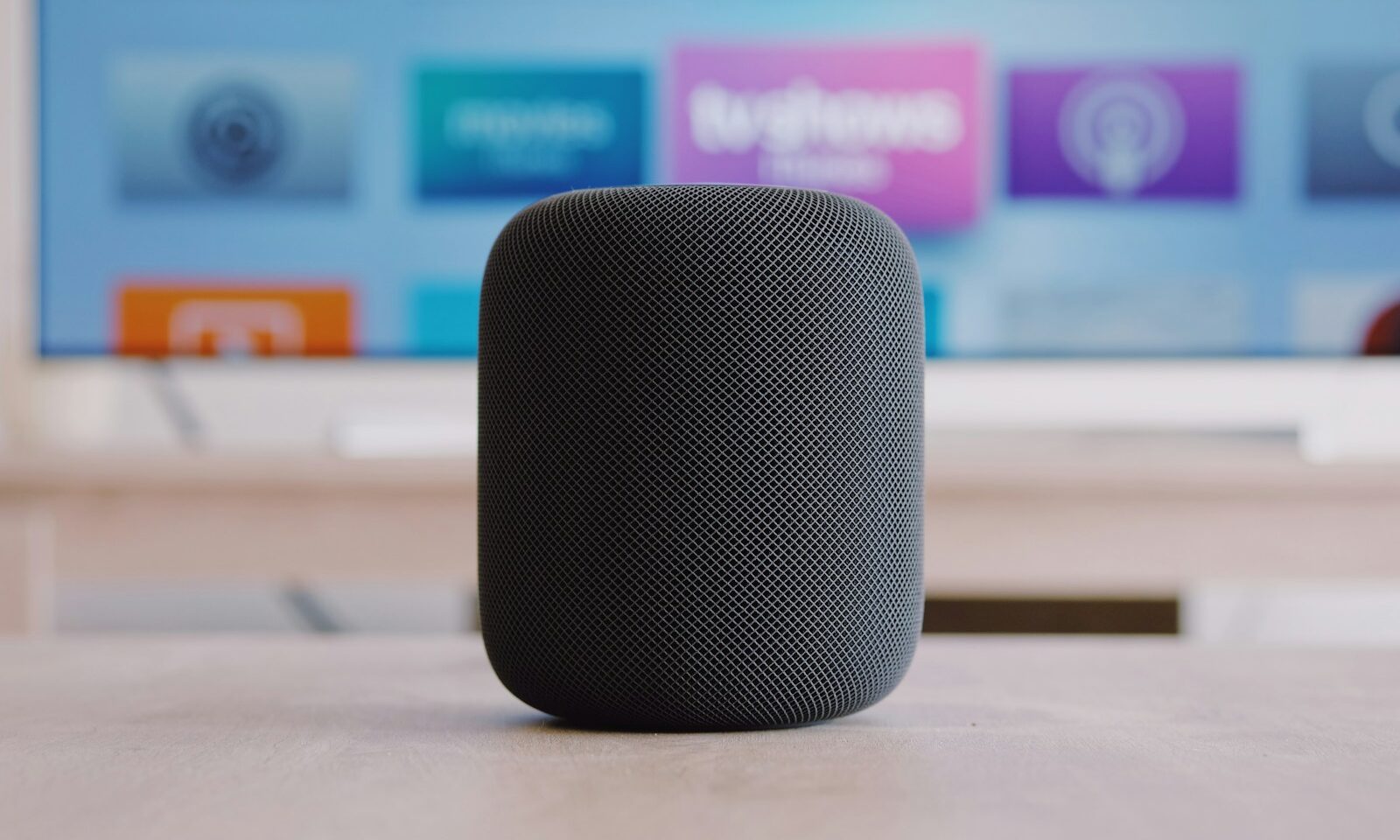 An original black Apple HomePod speaker on a table; not Apple HomeView